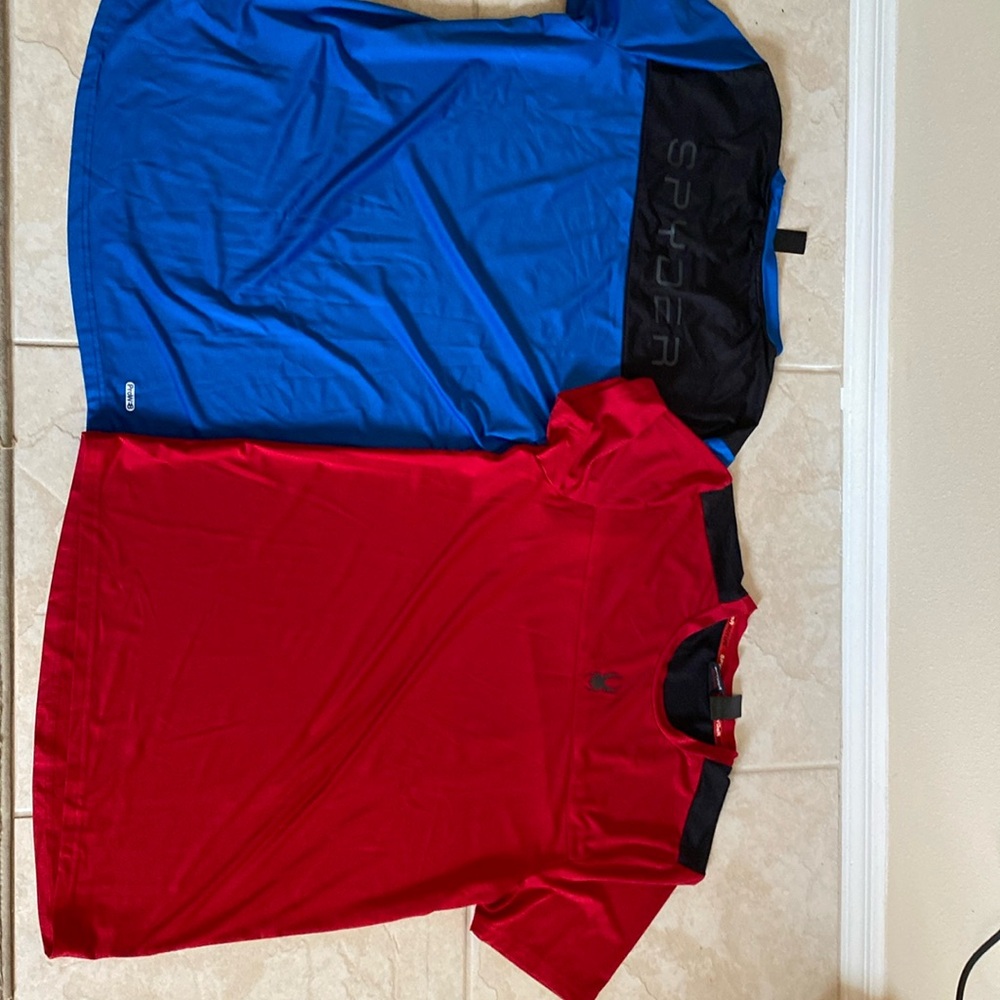Two men’s spider activewear shirts, one in red one in blue